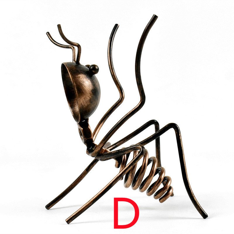 Bronze-coloured metal ant in pose D, reared up on its hind legs, marked with a red letter D
