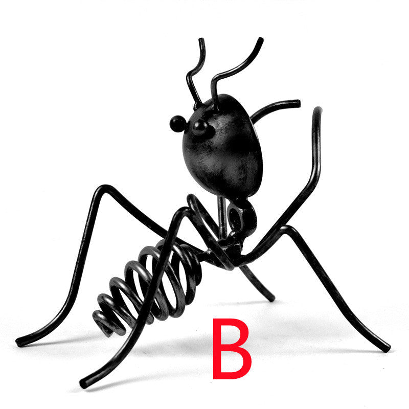 Black metal ant in pose B, standing with its head raised, marked with a red letter B