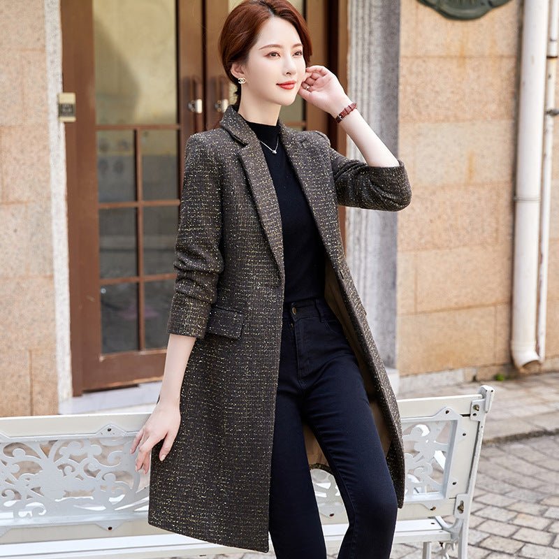 Dark brown tweed-look coat worn open, sleeves pushed up, hem around the knee