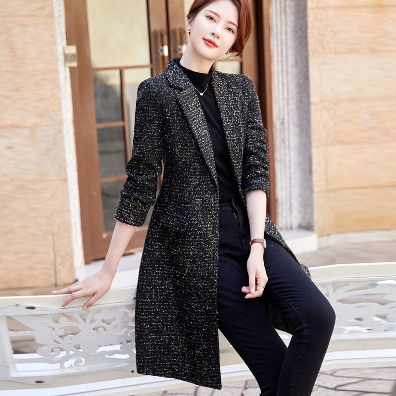 Black fleck coat worn open, model leaning on a white bench