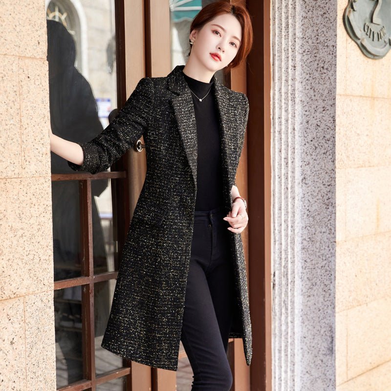 Black mid-length coat with gold-coloured flecks, worn open over black clothes