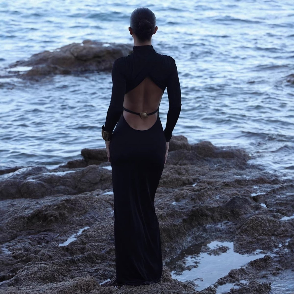 Back view of the black dress showing the open back and the thin strap with a gold-tone ring