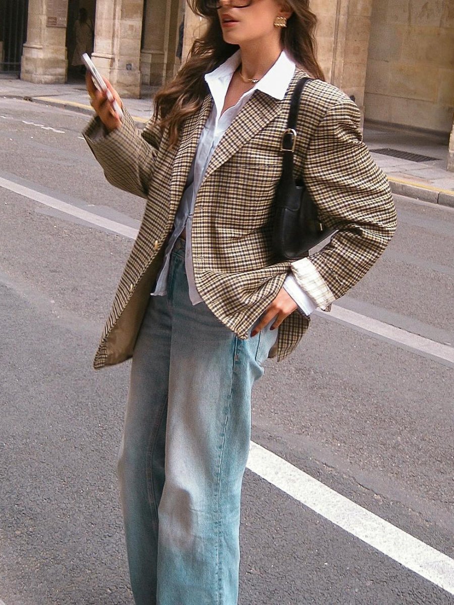 Check blazer worn open with a hand in the jeans pocket, showing the flap pocket and folded shirt cuffs