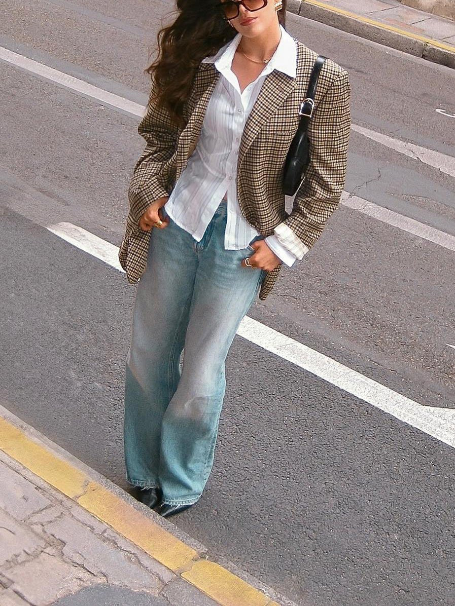Full-length view of the oversized blazer with wide light-blue jeans on a street