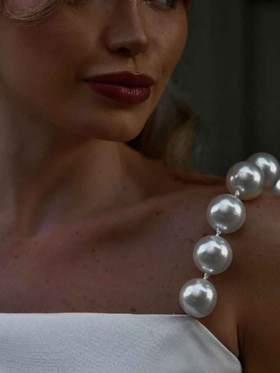 Close-up of a strap of large pearl-look beads on the shoulder