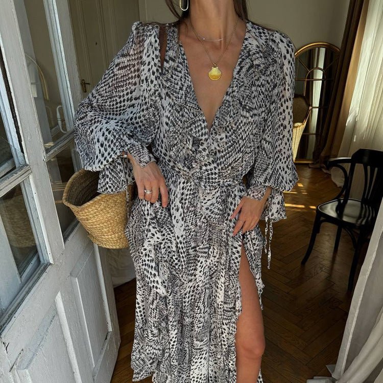 Black and white print wrap dress with a tied waist and slit, gold-tone necklace as a prop