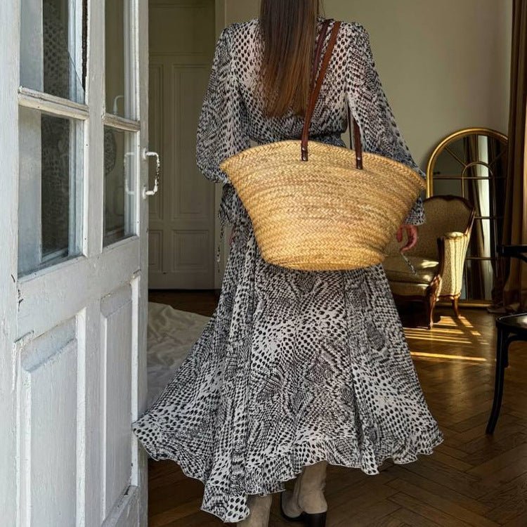 Black and white print maxi dress with a ruffled hem, worn with a straw tote