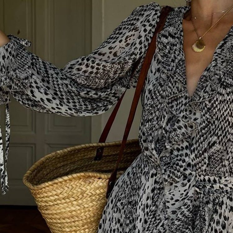 Close-up of the V-neck and balloon sleeve of the black and white print dress, straw tote on the shoulder
