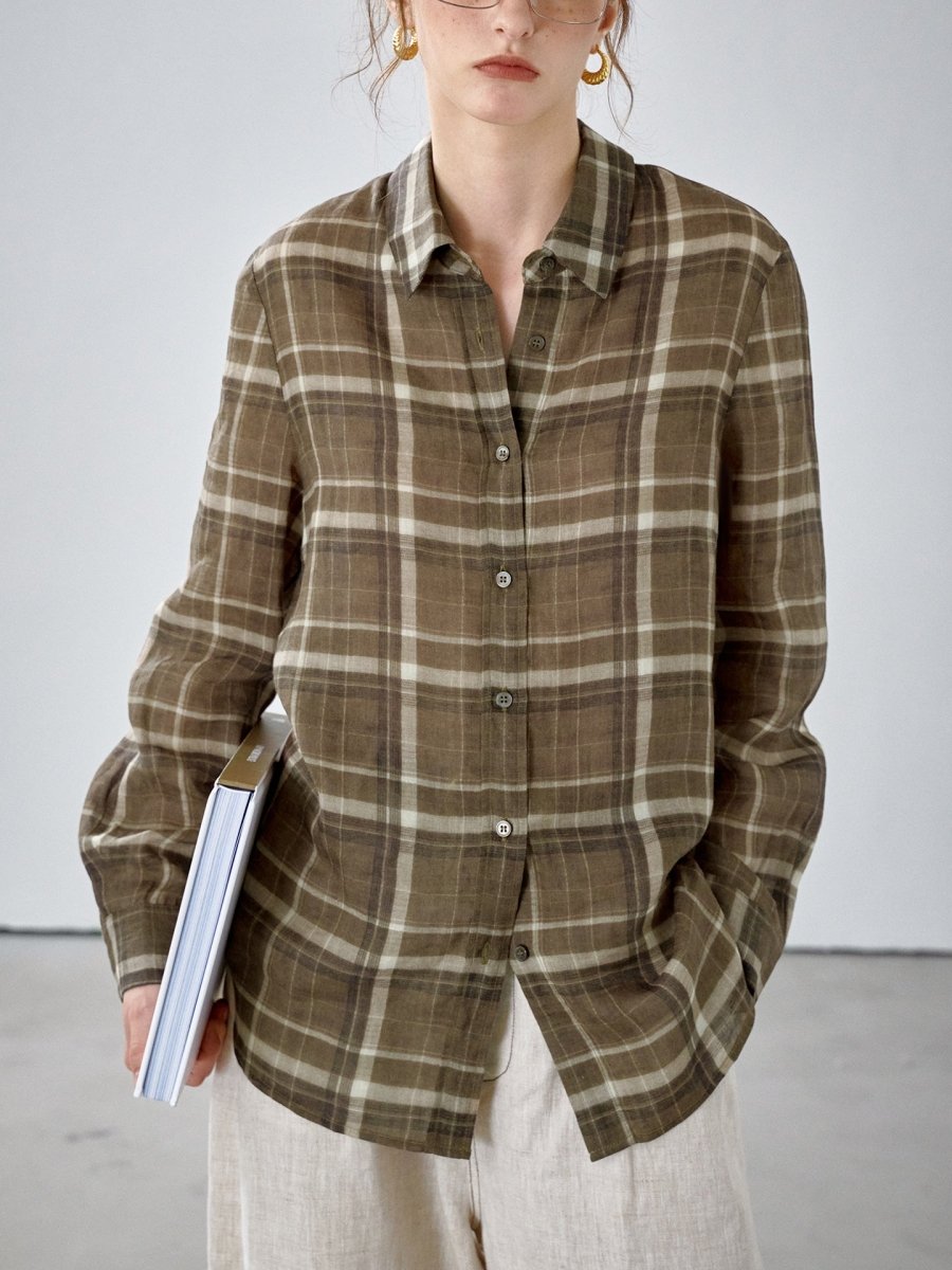 Front of the olive brown check shirt with point collar and button front, model holding a book