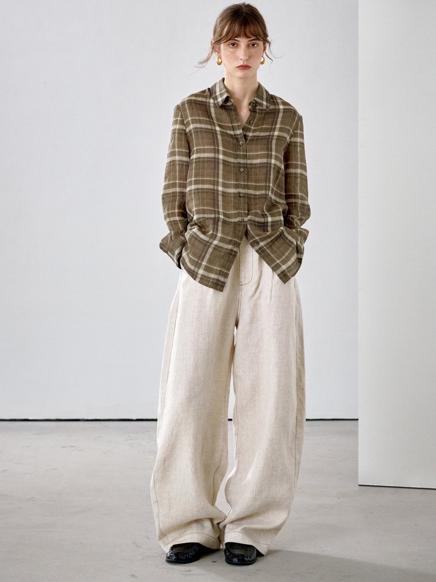 Full-length view of the olive brown check shirt with cream wide-leg trousers and black shoes