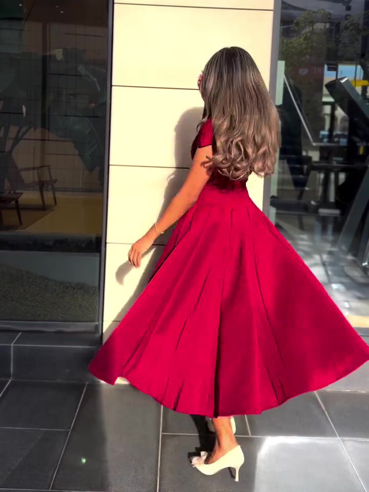 Model turning in the red dress, the flared skirt swinging out in wide folds