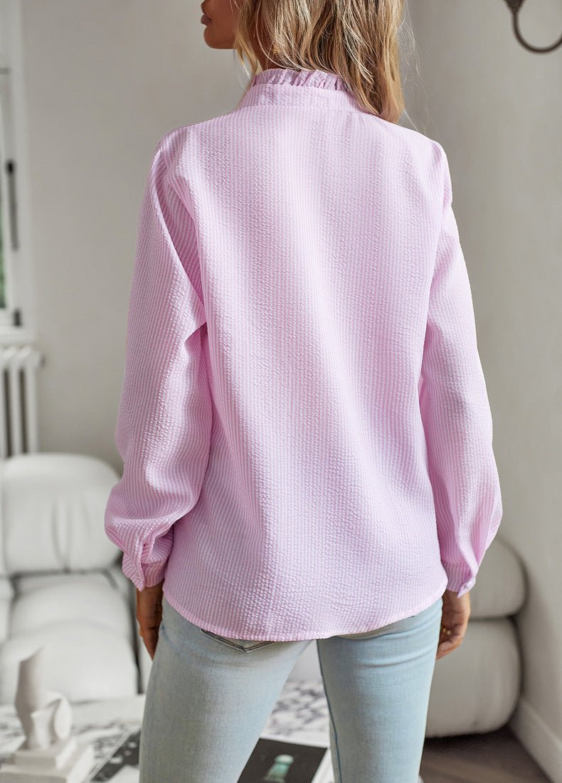 Back view of the pink blouse with long sleeves and a curved hem
