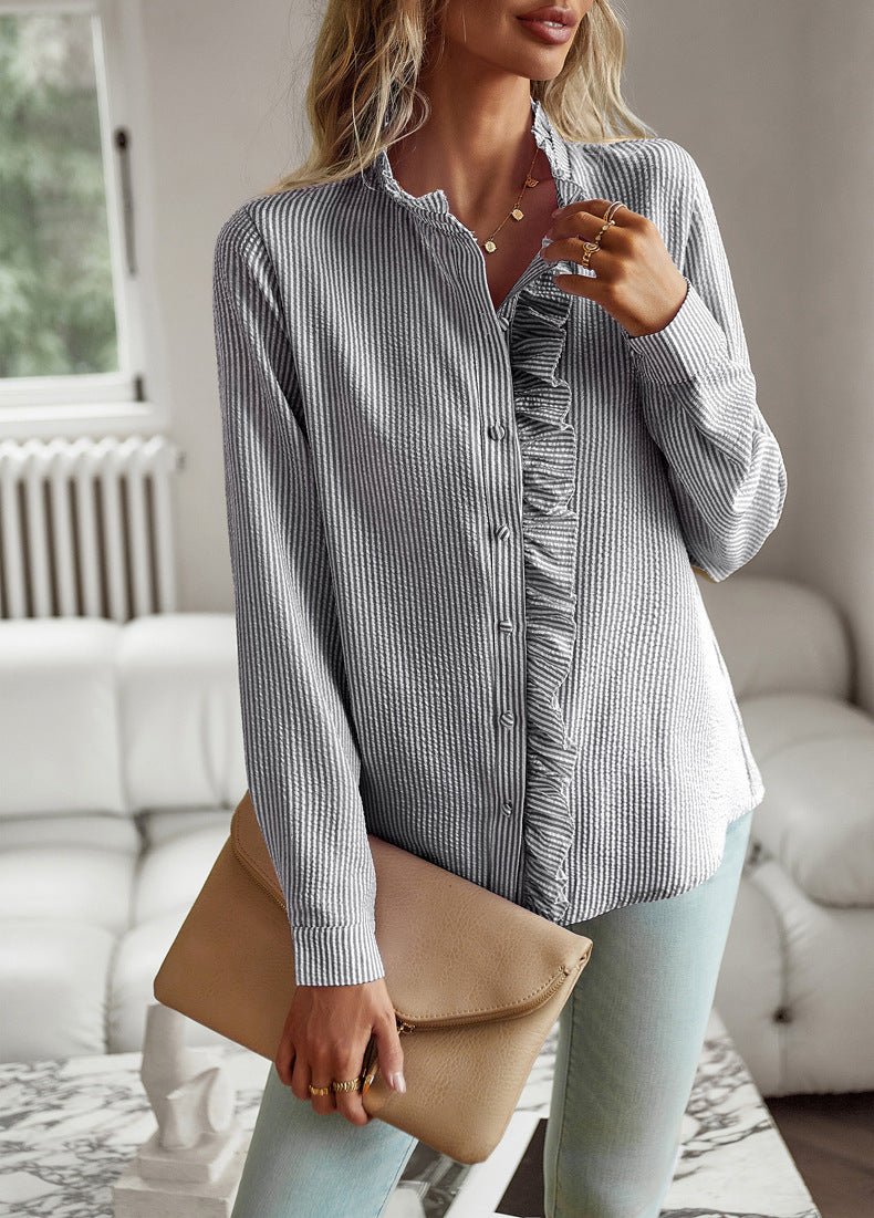 Black stripe blouse with a beige clutch, front view
