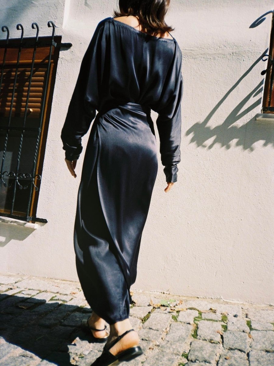 Back view of the navy dress with wide long sleeves and a tied waist
