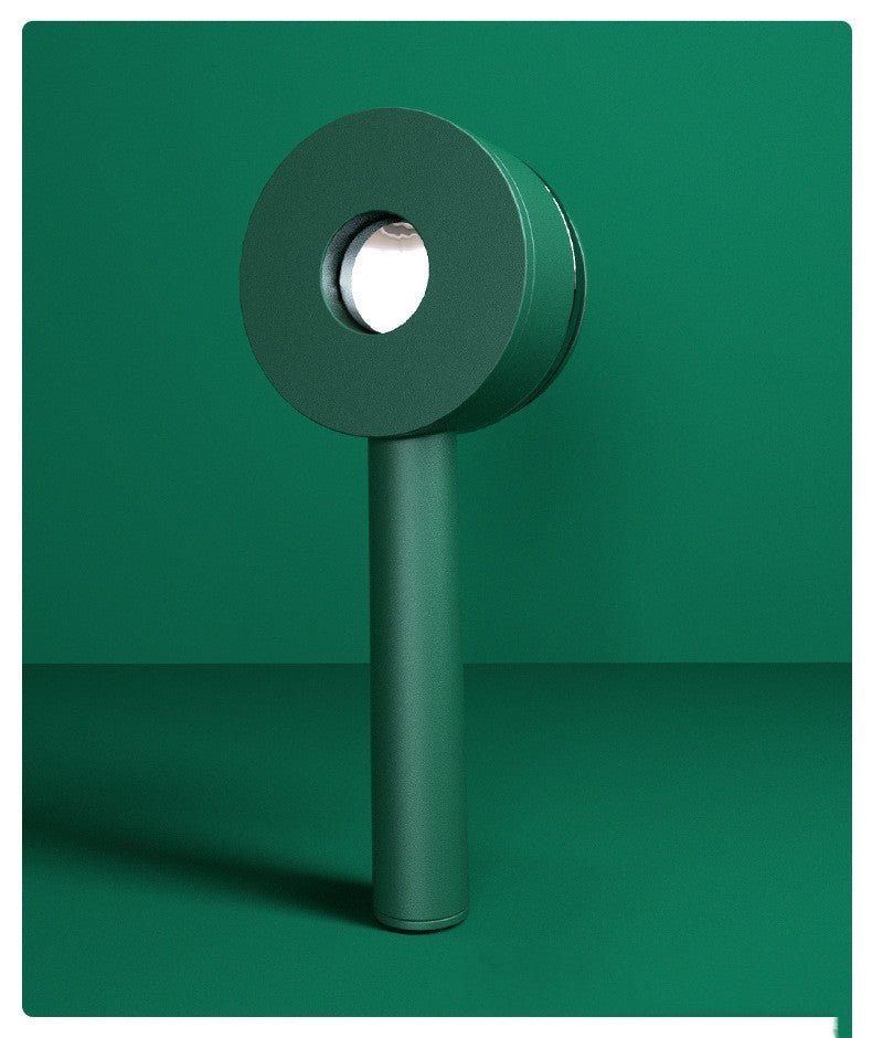 Back of the green hairbrush showing the round push button
