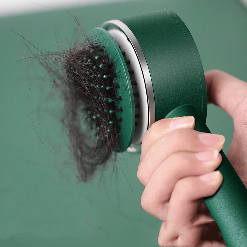 Hand pressing the button on the green hairbrush while a mat of hair lifts off the pins