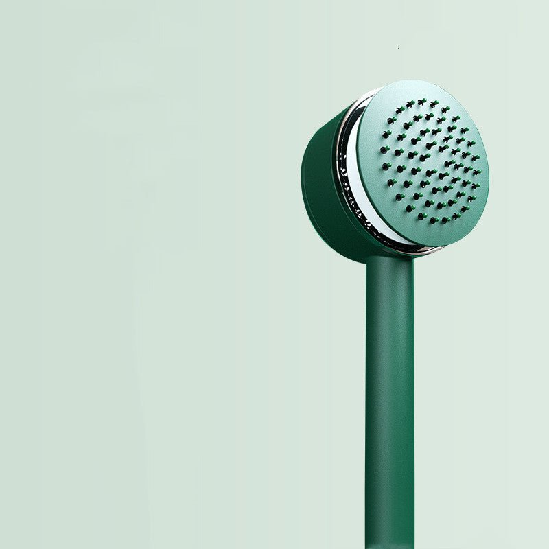 Green hairbrush seen at an angle with the cushion pushed up between the pins