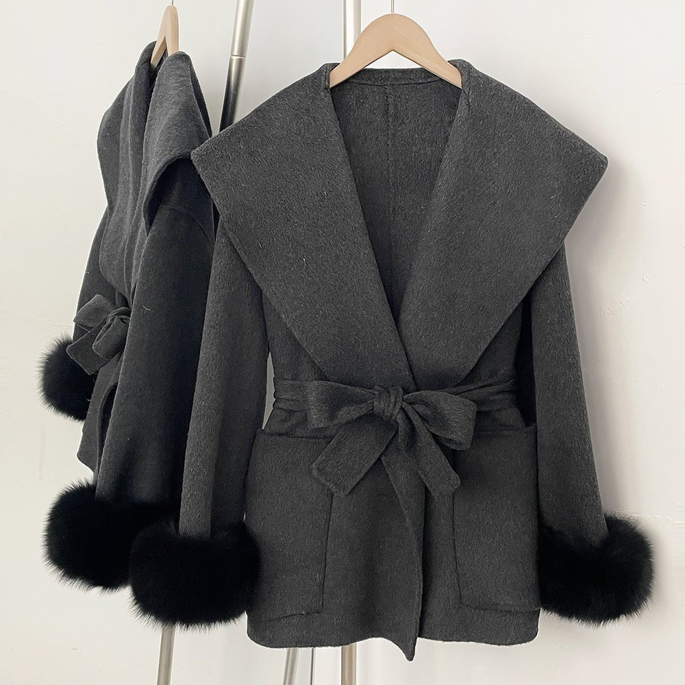 Short wrap coat with wide collar and fluffy cuffs in dark grey, front view on hanger