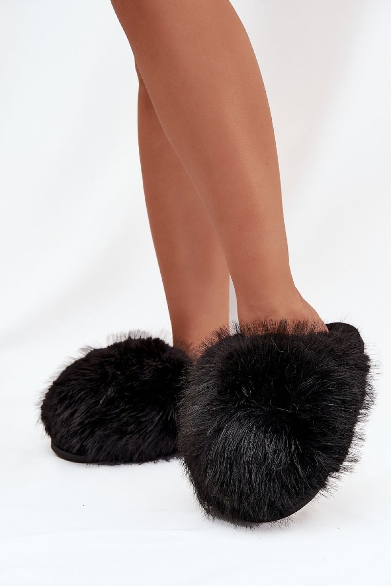 Fur slippers on model's feet demonstrating fit