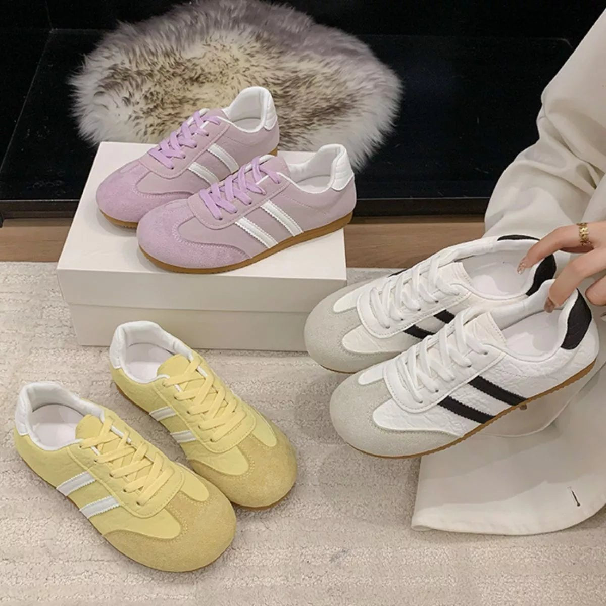 White and black striped lace-up casual sneakers with flat rubber sole, designed for everyday wear