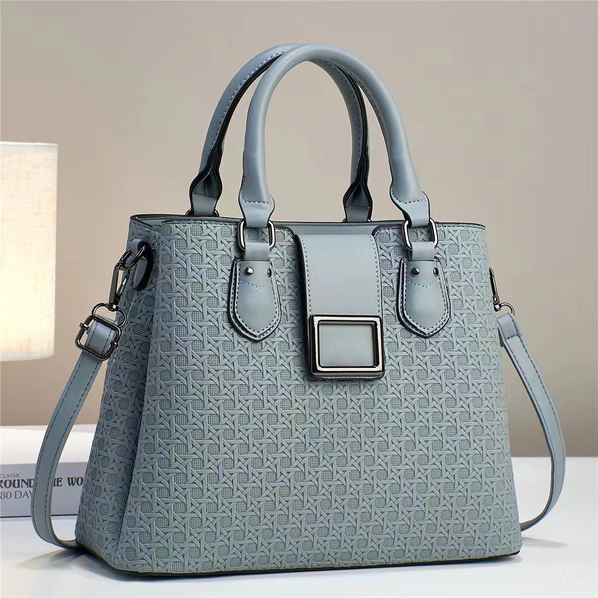 Grey-blue embossed handbag standing upright