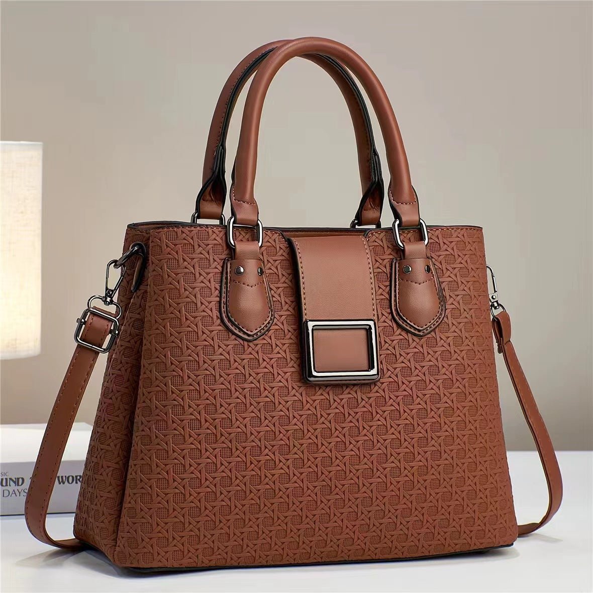 Brown structured handbag with embossed pattern and silver-coloured tab frame