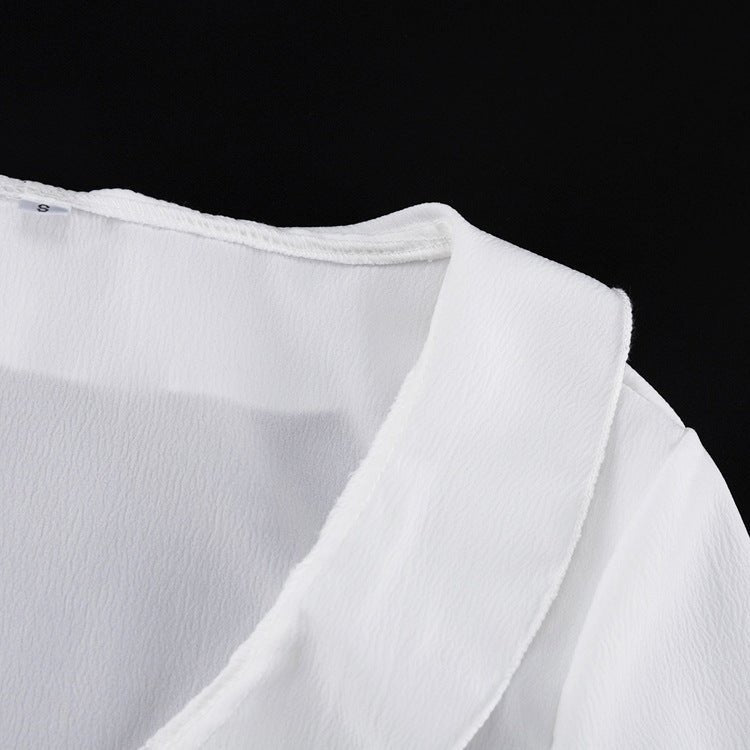 Collar detail of the white top, fabric slightly sheer