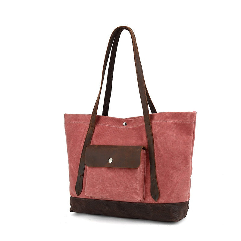 Rose rode waxed canvas tas, schuine vooraanzicht met leren hengsels en leren bodem