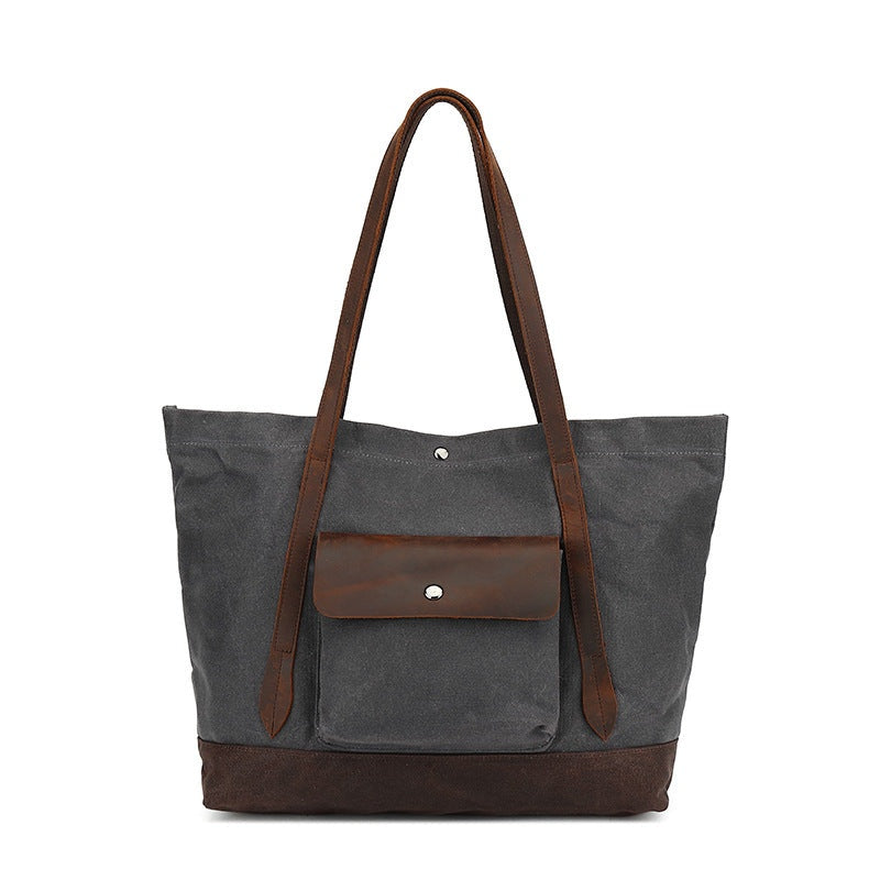 Grijze waxed canvas tas met bruine leren details, vooraanzicht