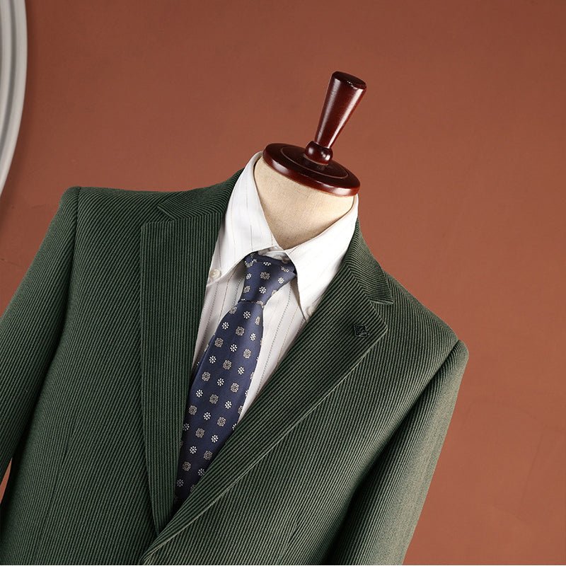 Close-up of the green blazer's notch lapel, lapel pin and fine ribbed fabric