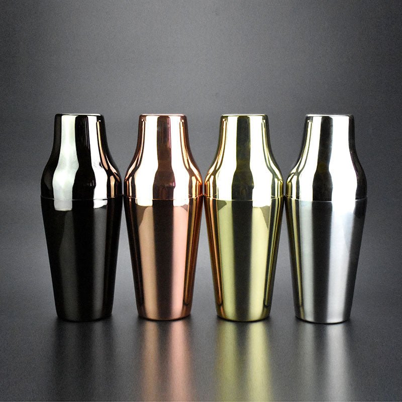 Vier tweedelige cocktailshakers rechtopstaand in de afwerkingen zwart, rosé goud, goudkleurig en zilver