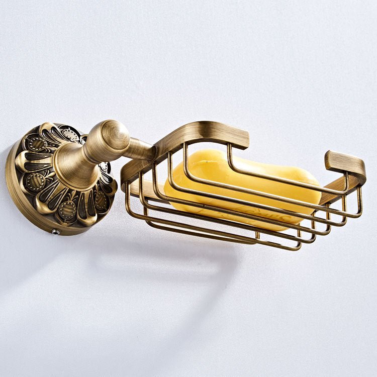 Wall-mounted wire soap basket in an antique bronze finish holding a yellow bar of soap