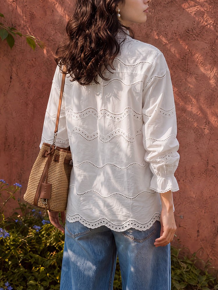 Back view of the eyelet blouse with wavy embroidery across the back and gathered cuffs