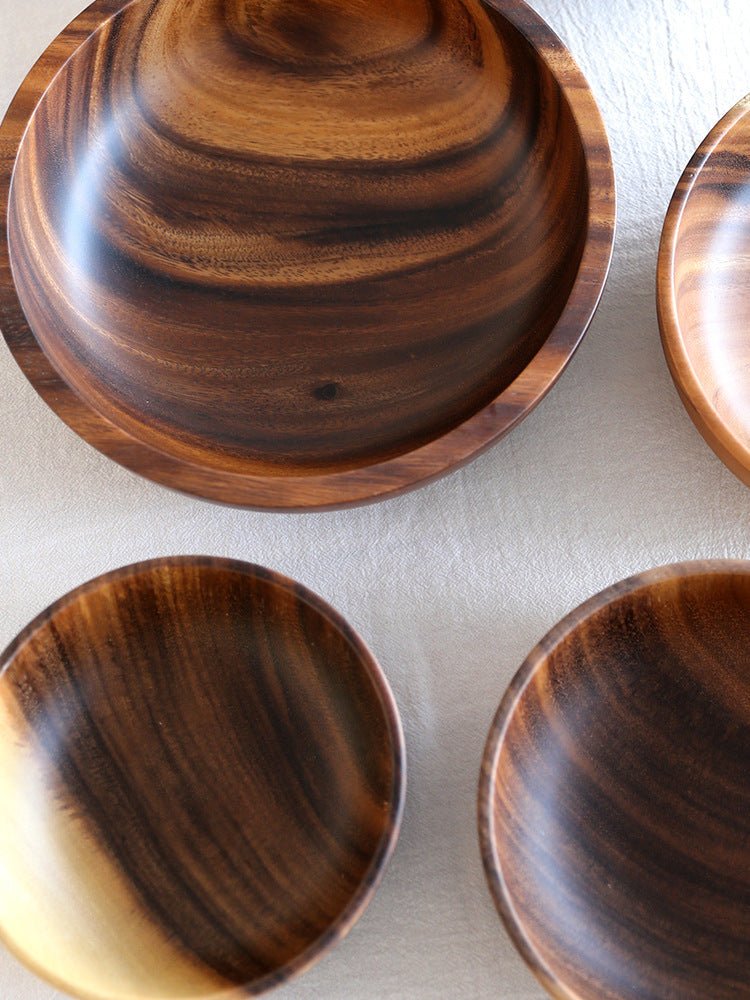 Close-up of four wooden bowls with dark grain arranged in a square pattern
